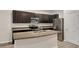 Contemporary kitchen with stainless steel appliances, an island, and dark cabinets at 518 Glenn Cross Dr, Ruskin, FL 33570