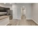 Open-concept living space with laminate wood flooring, white walls, and entry to kitchen at 518 Glenn Cross Dr, Ruskin, FL 33570