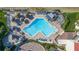 Aerial view of a large community pool with lounge chairs and umbrellas and nearby beach at 5505 Puerta Del Sol S Blvd # 427, St Petersburg, FL 33715