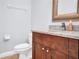 Bathroom features a wooden vanity, granite countertop, framed mirror, and a white toilet at 642 Blue Taverna Ln, Clearwater, FL 33756