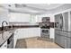 Modern kitchen with stainless steel appliances, granite countertops, and ample cabinet space at 642 Blue Taverna Ln, Clearwater, FL 33756