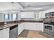 Well-equipped kitchen featuring stainless steel appliances, white cabinets, and a view to living area at 642 Blue Taverna Ln, Clearwater, FL 33756