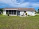 Backyard patio with white chairs and views of the lawn at 6707 Thorman Rd, Port Charlotte, FL 33981