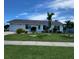 Charming home with a well-manicured front yard, lush lawn, and tropical landscaping at 6707 Thorman Rd, Port Charlotte, FL 33981