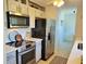 Galley kitchen featuring stainless steel appliances, tile backsplash and undermount microwave at 6707 Thorman Rd, Port Charlotte, FL 33981