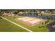 Aerial view of tennis courts surrounded by lush landscaping and a tranquil pond at 6707 Thorman Rd, Port Charlotte, FL 33981