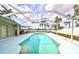 Backyard pool area with screened enclosure, green lawn, lake views, and ample patio seating at 6725 Clair Shore Dr, Apollo Beach, FL 33572