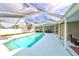 Private pool area with screened enclosure, green lawn, lake views, and outdoor seating at 6725 Clair Shore Dr, Apollo Beach, FL 33572