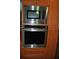 Stainless steel appliances including a microwave and oven are surrounded by orange cabinets at 7219 Williams S Dr, St Petersburg, FL 33705