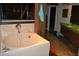 Bright bathroom featuring a modern tub, green countertop, and unique wood beam accent at 7219 Williams S Dr, St Petersburg, FL 33705