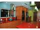 Bright kitchen with a stainless steel range hood, red countertops, and orange cabinetry at 7219 Williams S Dr, St Petersburg, FL 33705