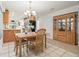 Elegant dining area with neutral tones, modern chandelier, and built in cabinetry with glass doors at 7310 Sunshine Skyway S Ln # 219, St Petersburg, FL 33711