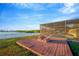 Scenic waterfront backyard featuring a fire pit, screened pool enclosure, and lush landscaping at 8841 W Millpoint Rd, Riverview, FL 33578