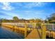 Home features a waterfront backyard including a white fence, wooden dock, and screened-in patio at 8841 W Millpoint Rd, Riverview, FL 33578