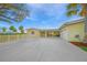 Charming yellow home with a spacious driveway, attached garage and lush landscaping at 8841 W Millpoint Rd, Riverview, FL 33578