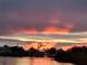 Serene waterfront view featuring a pastel sunset over the water and houses at 8841 W Millpoint Rd, Riverview, FL 33578