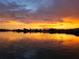 Golden sunset reflects on the water, highlighting a tranquil waterfront home at 8841 W Millpoint Rd, Riverview, FL 33578
