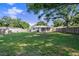 Spacious backyard with lush green lawn and mature trees, enclosed by wood fencing, perfect for outdoor activities at 917 2Nd Nw Ave, Largo, FL 33770
