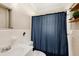 Compact bathroom with a blue shower curtain, tiled walls, and shelving at 917 2Nd Nw Ave, Largo, FL 33770