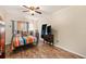 Cozy bedroom featuring wood-look floors, ceiling fan, and bright, colorful striped bedding at 917 2Nd Nw Ave, Largo, FL 33770