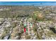 Expansive aerial view of a neighborhood, showcasing trees, baseball fields, pond, and homes near the coast at 1095 Jackmar Rd, Dunedin, FL 34698