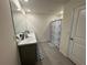 Bathroom featuring double vanity, marble counters, shower, and geometric patterned rugs at 11517 Timber Grove Ln, Brooksville, FL 34613