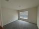 Clean bedroom with neutral carpet, paint, and a sunlit window at 11517 Timber Grove Ln, Brooksville, FL 34613