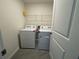 Bright laundry room features tile flooring, shelving, and modern washer and dryer units at 11517 Timber Grove Ln, Brooksville, FL 34613
