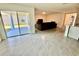 Bright open floor plan featuring a living room, kitchen island with seating, and sliding glass doors at 11517 Timber Grove Ln, Brooksville, FL 34613