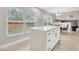 Bright kitchen featuring an island with a quartz countertop, white cabinets, and views of the backyard at 1208 Briarpark Way, Valrico, FL 33596