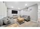 Inviting living room with comfortable gray couches, a wooden coffee table, and a wall-mounted TV at 1208 Briarpark Way, Valrico, FL 33596