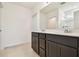 Bathroom features double vanity with dark wood cabinets, tile floors and a large mirror at 12823 Wanderlust Pl, Parrish, FL 34219