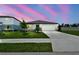 Beautiful home exterior with a manicured lawn at dusk at 12823 Wanderlust Pl, Parrish, FL 34219