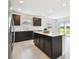 Modern kitchen boasts an island with quartz countertop, stainless steel appliances, and ample cabinet space at 12823 Wanderlust Pl, Parrish, FL 34219