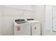 Clean laundry room with modern appliances and overhead shelving at 12823 Wanderlust Pl, Parrish, FL 34219