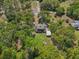 Bird's-eye view of a home surrounded by mature trees, a lawn and a rustic outbuilding at 14206 Walden Sheffield Rd, Dover, FL 33527