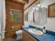 Cozy bathroom featuring wood and white walls, a window, toilet, and wooden vanity at 14206 Walden Sheffield Rd, Dover, FL 33527