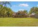 Wide shot of a log cabin home with a large front yard and rustic outbuilding at 14206 Walden Sheffield Rd, Dover, FL 33527