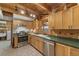 Well-lit kitchen featuring natural wood cabinets, stainless steel appliances, and green countertops for a rustic touch at 14206 Walden Sheffield Rd, Dover, FL 33527