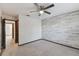 Bedroom featuring a wooden accent wall, neutral carpet and ceiling fan at 16519 Brigadoon Drive, Tampa, FL 33618