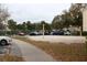 Sand volleyball court with net, surrounded by foliage and parking lot at 18415 Bridle Club Dr, Tampa, FL 33647