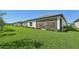 View of a long, lush green backyard with manicured hedges and view of the patio at 1848 Sunset Preserve Way, Port Charlotte, FL 33953