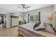 Relaxing bedroom with wood-look floors, dresser with TV, ceiling fan, and exercise bike at 1848 Sunset Preserve Way, Port Charlotte, FL 33953