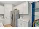 Kitchen with stainless steel refrigerator and plentiful white cabinetry for storage and organization at 1848 Sunset Preserve Way, Port Charlotte, FL 33953