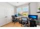 Well-lit home office featuring two desks, multiple monitors, and a large window for natural light at 1848 Sunset Preserve Way, Port Charlotte, FL 33953