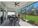 An outdoor patio features wicker furniture, a ceiling fan and views of the green lawn at 1848 Sunset Preserve Way, Port Charlotte, FL 33953