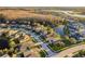 Aerial view of a residential area featuring manicured lawns, homes, and a lake with a wooded area at 19122 Sunset Bay Dr, Land O Lakes, FL 34638