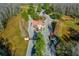 Stunning aerial view of community entrance featuring manicured landscaping, pond and charming white guardhouse with a red roof at 19122 Sunset Bay Dr, Land O Lakes, FL 34638