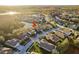 An aerial view of a house nestled in a lovely neighborhood with ponds and mature trees at 19122 Sunset Bay Dr, Land O Lakes, FL 34638