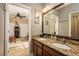 Bright bathroom featuring double sinks with granite counters and an ensuite Primary bedroom at 19122 Sunset Bay Dr, Land O Lakes, FL 34638